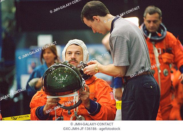 Astronaut Scott D. Altman, STS-109 mission commander, dons a training version of the full-pressure launch and entry suit prior to a training session in one of...