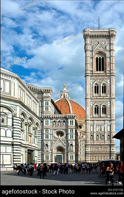 Tourists on the Piazza del duomo in front of the Cathedral of Santa Maria del Fiore with Giotto's campanile in Florence - Italy