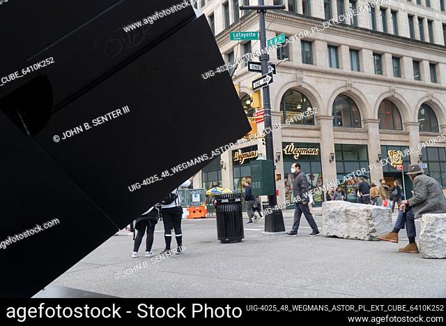 A view of the SE corner and the entrance to Wegmans store as seen from behind the Astor Place Cube, a large black sculpture created by Tony Rosenthal in 1966...
