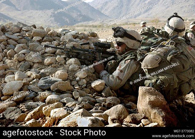 AFGHANISTAN Zabul Province -- 23 Oct 2004 -- A US Army soldier sets up a defensive position with his M-249 Squad Automatic Weapon during a patrol in the...