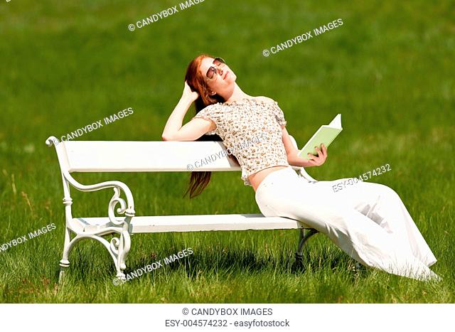 Summer - young woman relaxing bench park
