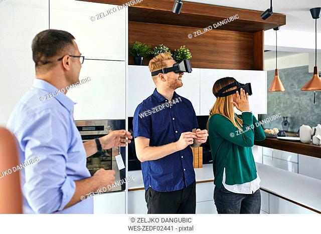 Couple wearing VR glasses shopping for a new kitchen in showroom