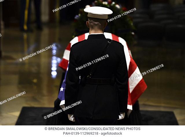A member of the military stands watch over the flag draped casket of former President George H.W. Bush in the Capitol Rotunda in Washington, DC, December 3