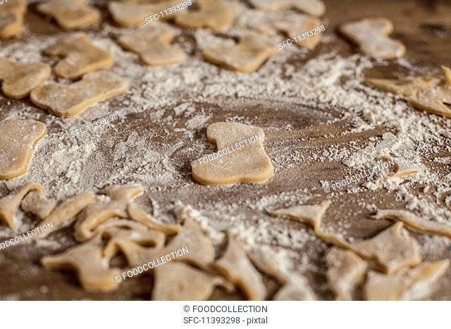 Cut-out biscuits and leftover pastry on a floured work surface