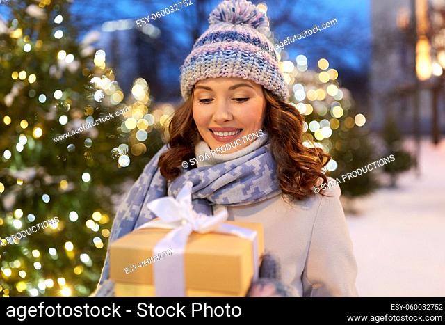 happy young woman with christmas gift in winter