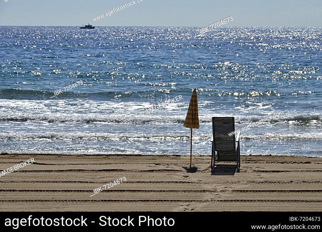 Cleaned beach with deckchair, sunshade and fishing boat, Hospitalet dEnfant, Catalonia, Spain, Europe