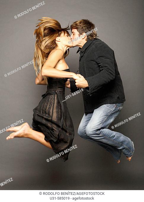 Young couple kissing in the air