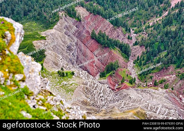 21 July 2023, Italy, St. Ulrich: Reddish colored stone formations can be seen on a slope near the top of the Seceda mountain
