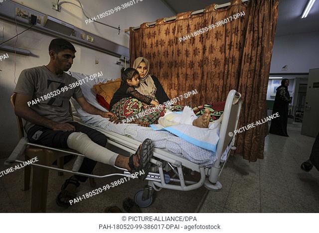 dpatop - Palestinian woman Asma Abu Daqah (R) and her husband Mohammed Abu Daqah (L) lie inside a hospital with their daughter Lian after being injured during...