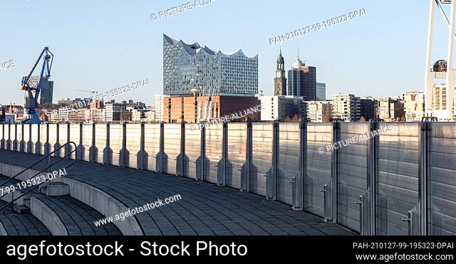 25 December 2020, Hamburg: The Elbphilharmonie, the tower of the Hauptkirche St. Michaelis and the Kehrwiederspitze can be seen on the opposite bank of the Elbe...