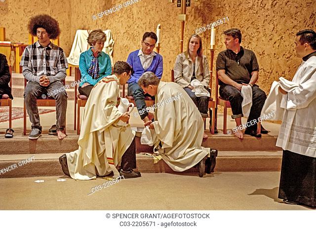 The robed pastor of St. Timothy's Catholic Church, Laguna Niguel, CA, washes the feet of parishioners on Holy Thursday mass in memory of Christ washing the feet...