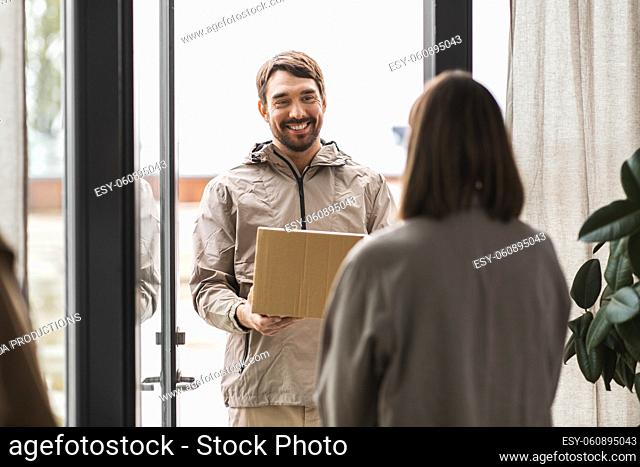 delivery man with parcel box and customer at home
