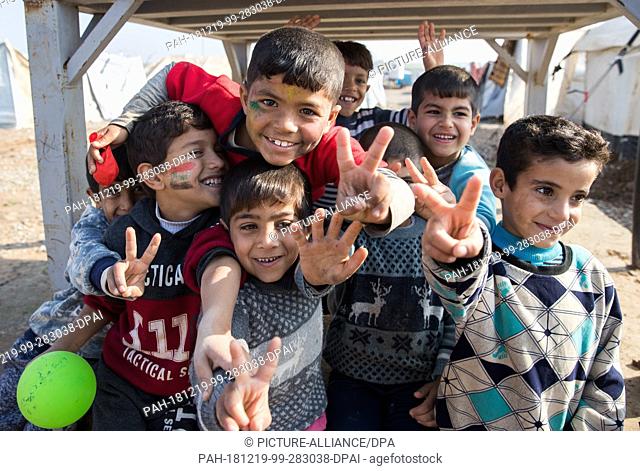 19 December 2018, Iraq, Erbil: During the visit of Foreign Minister Maas (SPD) to the refugee camp Hasan Sham, children are making the sign of victory