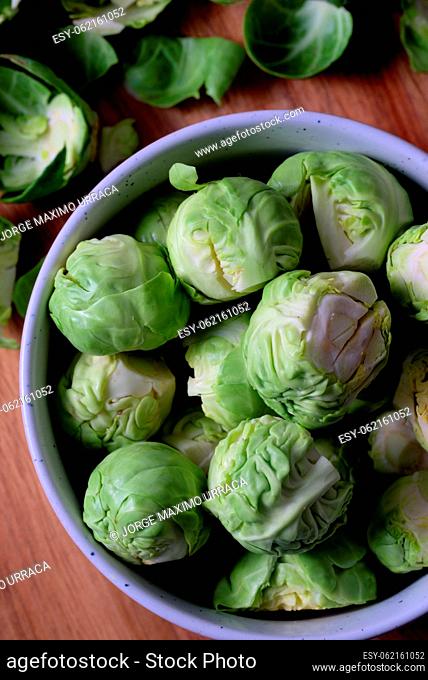 White bowl with delicious Brussels sprouts on wooden