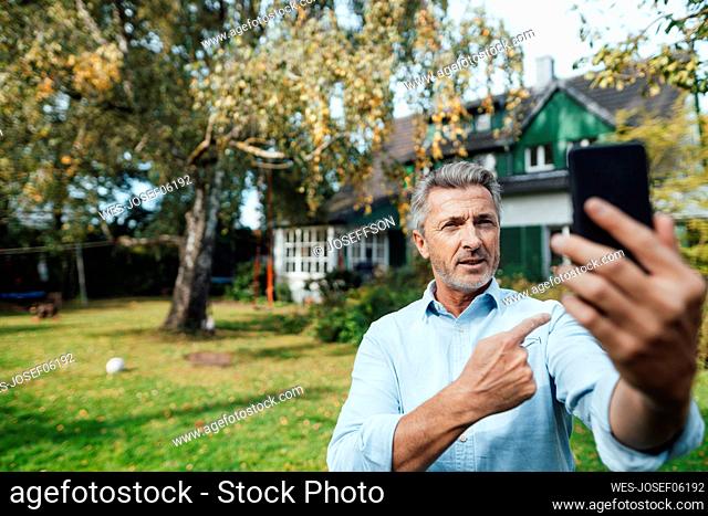 Man attending video call through mobile phone at backyard