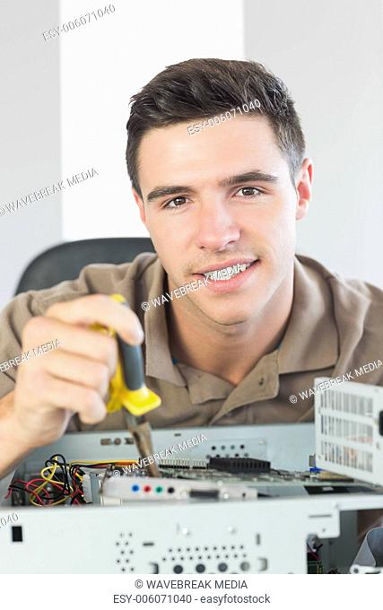 Handsome happy computer engineer repairing open computer