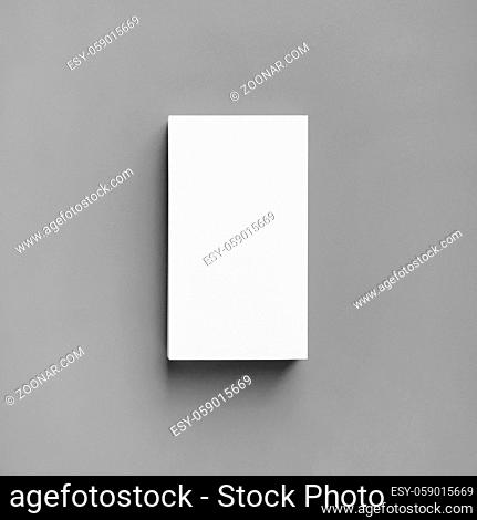Blank white business card on gray paper background. Mockup for branding identity. Top view. Flat lay