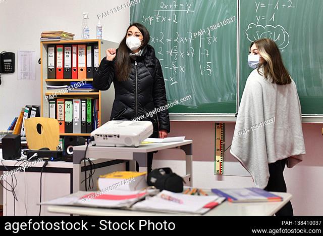 School lessons in times of the coronavirus pandemic. Teacher and student, student stand at a blackboard, school blackboard and do math problems