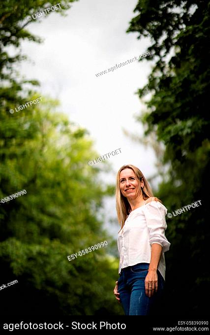 Portrait of a relaxed middle aged woman outdoors, looking happy, enjoying the life