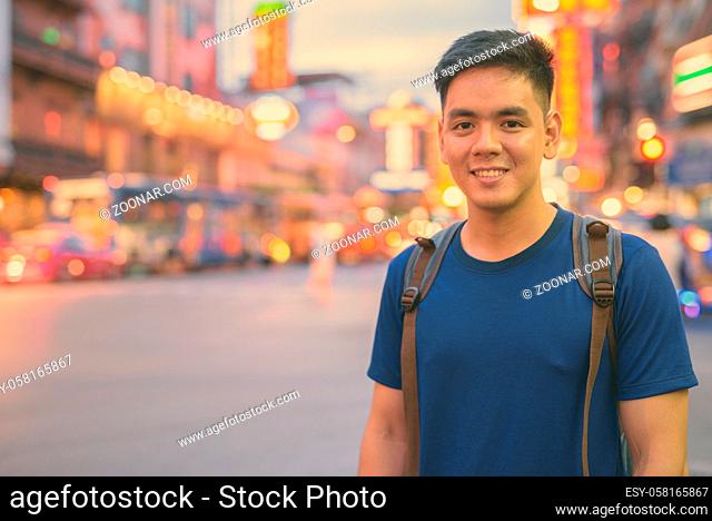 Portrait of young handsome Asian tourist man exploring at Chinatown in Bangkok, Thailand