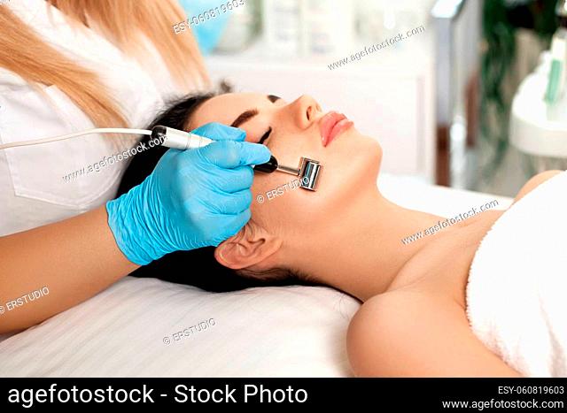Beautician makes Ultrasonic cleaning of the face in spa salon. cosmetology
