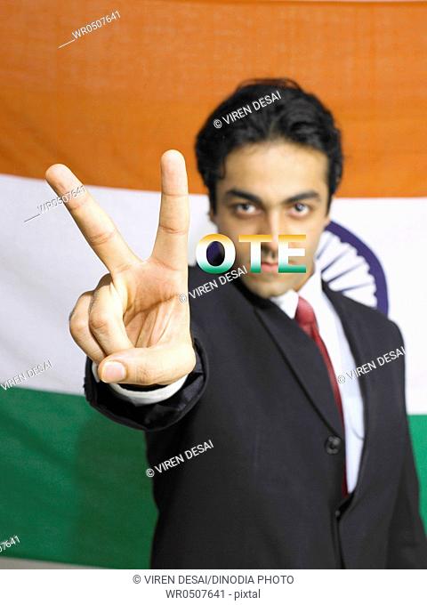 Executive showing victory sign standing in front of national flag of India MR702A