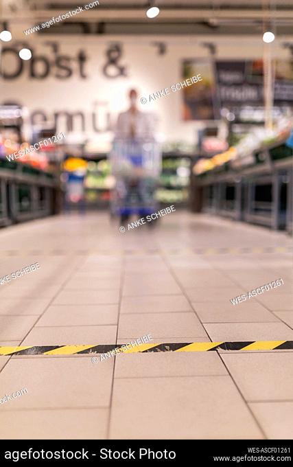 Sticky tape on tiled floor at supermarket