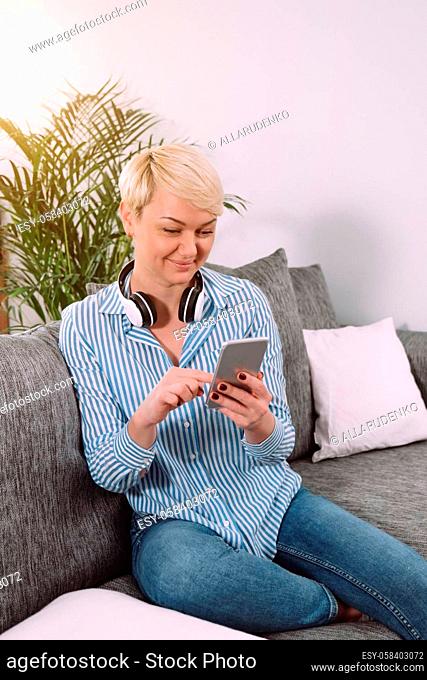 Happy Cheerful Young Woman Talking on Phone at Home Smiling Woman Relaxing on Sofa With Smartphone