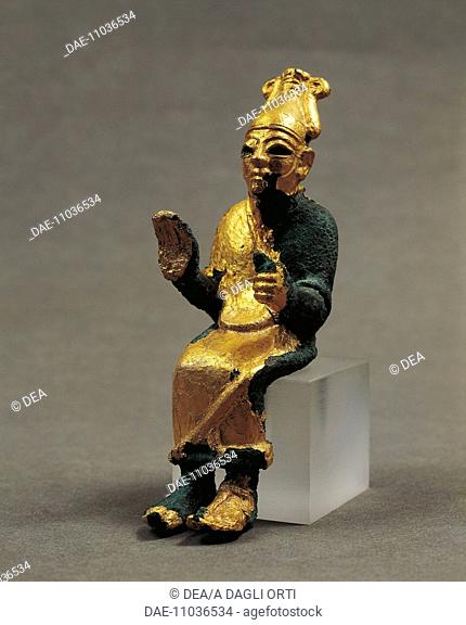 Gold leaf bronze statuette depicting a seated god giving a blessing. Artefact from Ugarit (today Ras Shamra), Syria. Assyrian civilisation, ca 1300 BC