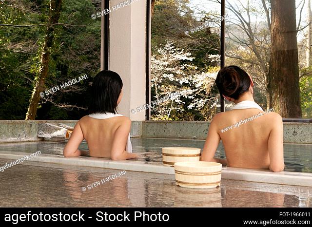Young women relaxing in tranquil pool at Onsen