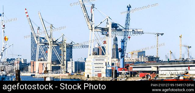 25 December 2020, Hamburg: Container cranes of the Hansa harbour, the Elbphilharmonie, the Kehrwiederspitze and the tower of the main church St