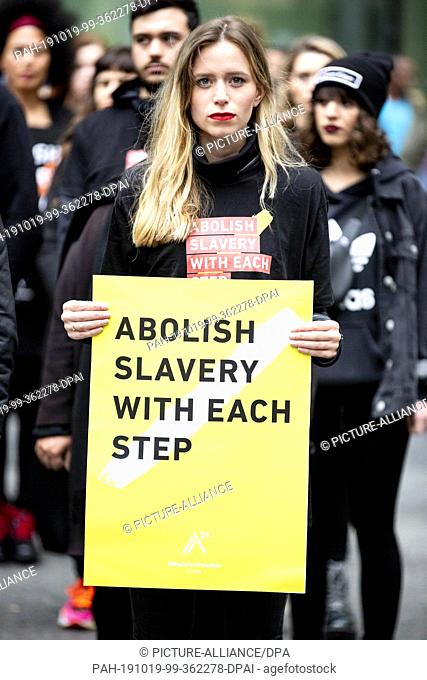 19 October 2019, Berlin: A participant of the worldwide ""Walk For Freedom"", a silent march against human trafficking, holds a poster at the final meeting near...