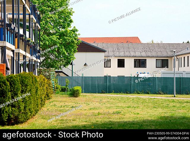 05 May 2023, Berlin: The white buildings with the detention rooms can be seen behind a green fence on the ""Open Day"" of the Berlin Open Prison