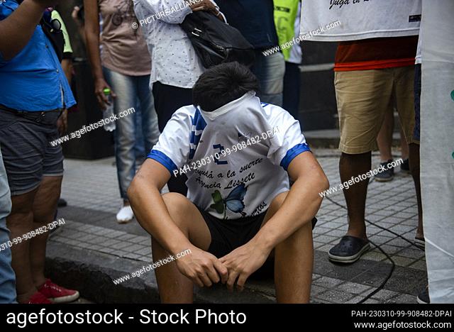 10 March 2023, Argentina, Rosario: A young man cries under his T-shirt during a rally following the murder of eleven-year-old boy Maximo Gerez by suspected drug...