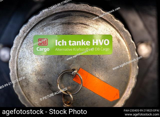05 April 2023, Bavaria, Munich: A sticker reading ""Ich tanke HVO - Alternative Kraftstoffe @ DB Cargo"" is stuck on the filler cap of a diesel locomotive