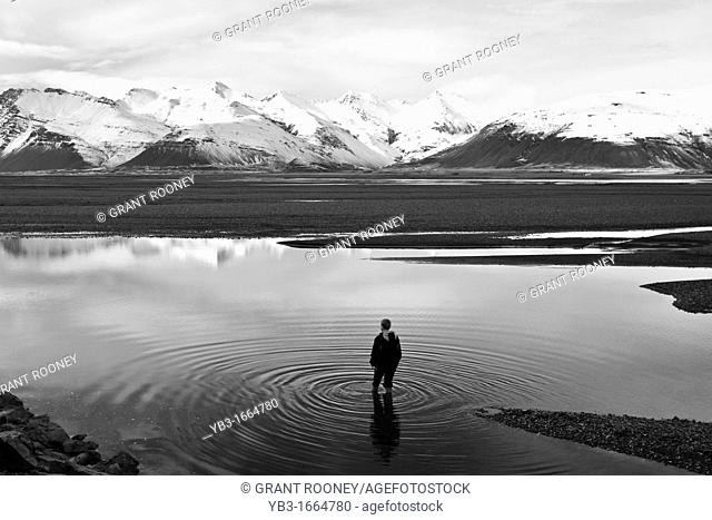 Boy standing in a Lake, near Hofn, Iceland