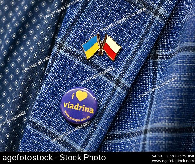 30 November 2023, Brandenburg, Frankfurt (Oder): A small flag of Ukraine and Poland as well as a pin of the European University Viadrina can be seen at the...