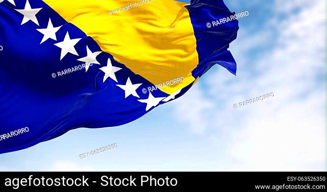 Flag of Bosnia and Herzegovina waving in the wind. Blue field with yellow triangle and white stars. 3d illustration render. Fluttering textile