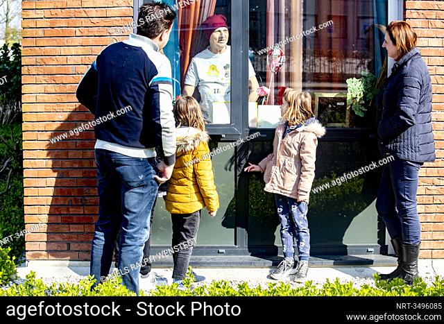 TILBURG - the Reijnen family says goodbye to their mother Mrs. van Baast and grandmother behind the window of a care home