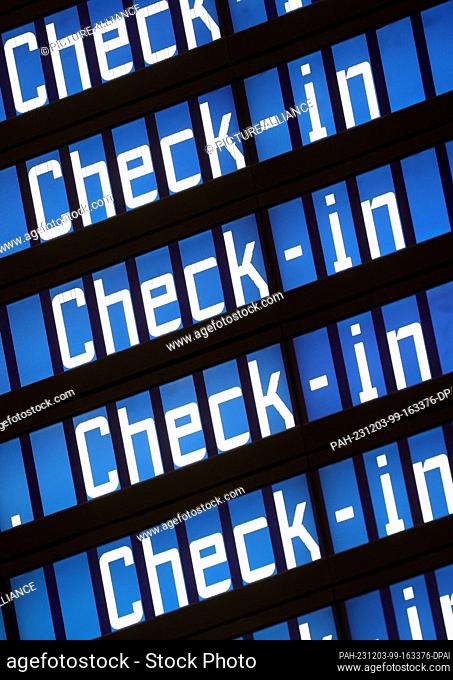 03 December 2023, Bavaria, Munich: ""Check-in"" can be read on an electronic display board at Munich Airport. Munich Airport resumed flight operations at 06:00...
