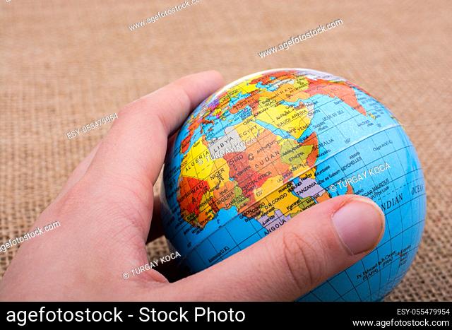 Globe in hand on a canvas background