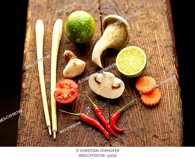 Ingredients for Asian Tom Kha Gai soup on wooden chopping board