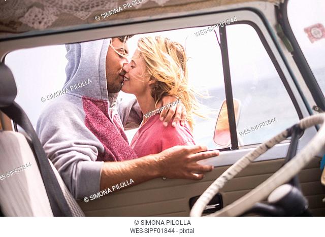 Spain, Tenerife, young couple in love on holidays with a van near the sea