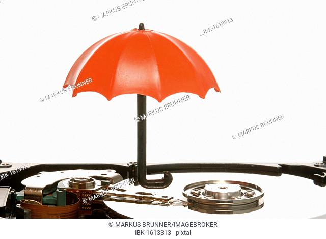 Small umbrella on a hard drive, symbolic image for data protection