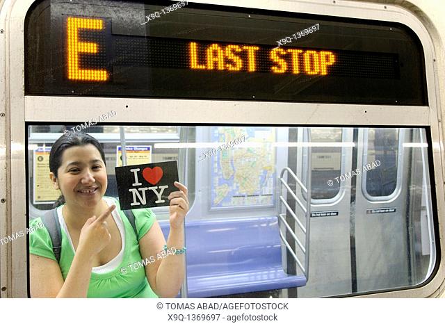 Hispanic, Asian, woman holding 'I Love New York' postcard, Subway train metro station, New York City