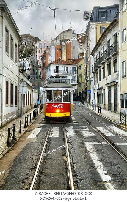 The popular tram 28 through the winding and narrow streets of Alfama. Lisbon, Portugal