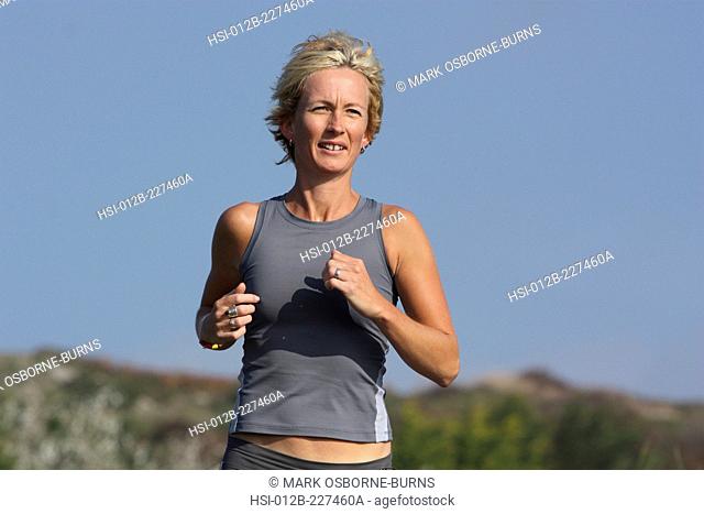 Blonde woman outdoors. Jogging close-up