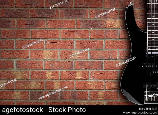A bass guitar on brick background with copy space