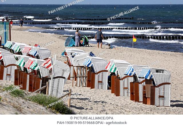 19 August 2019, Mecklenburg-Western Pomerania, Graal-Müritz: At the Baltic Sea beach many beach chairs are empty. Despite the sun there is no real beach weather