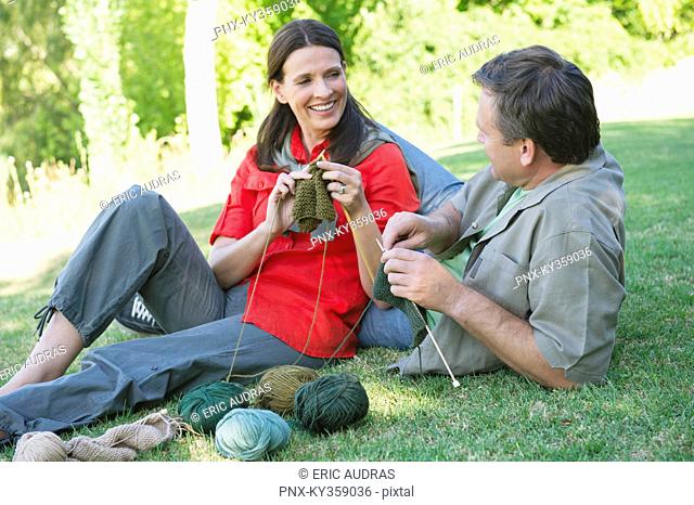 Mature couple knitting together in the garden